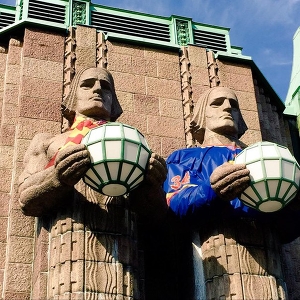 Каменные образы носителей светильников, на вокзале Хельсинки, оделись в цвета «Йокерит»