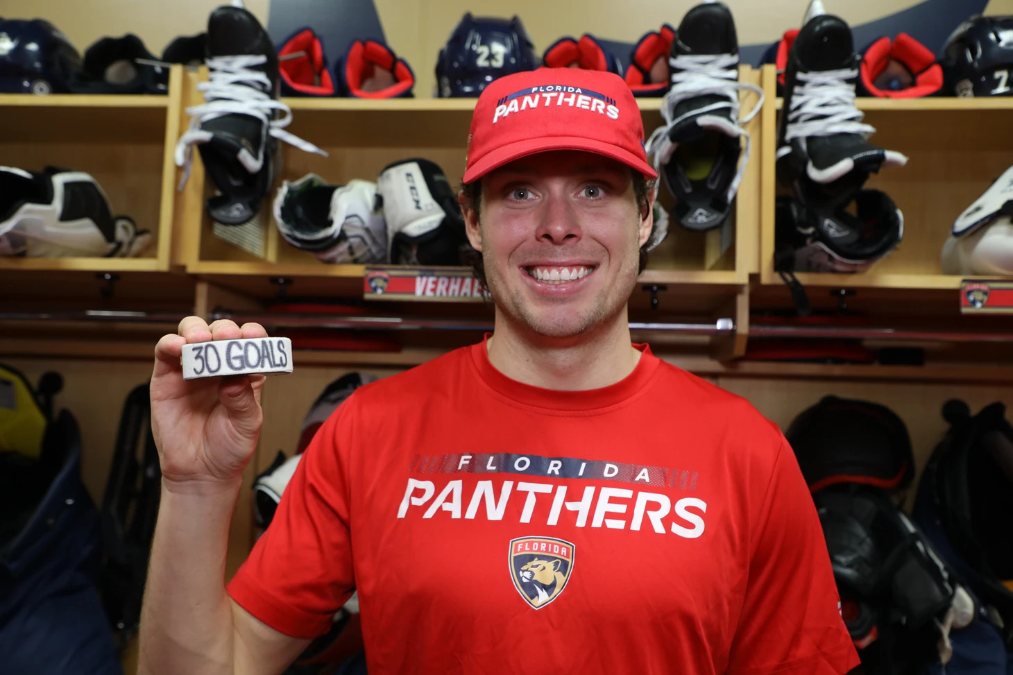 Florida Panthers forward Carter Verhaeghe poses with his 30-goal puck. It is the first time in his NHL career he has hit the mark.