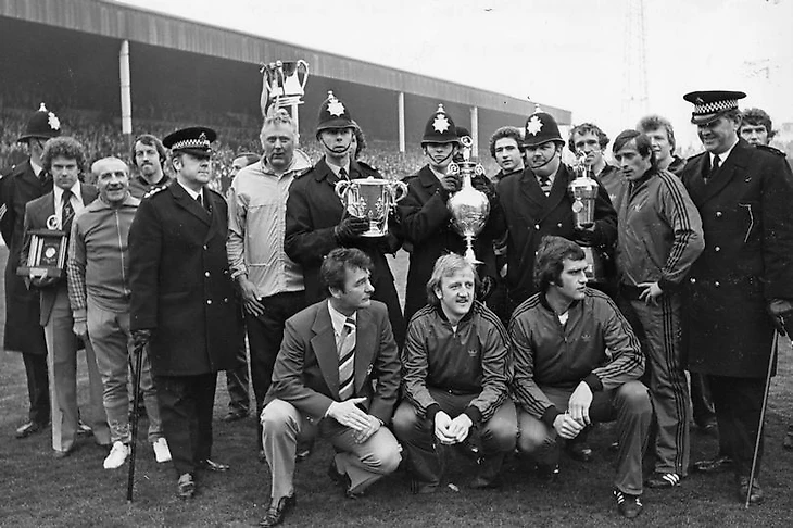 Брайан Клаф, Питер Тейлор и игроки демонстрируют с полицейскими кубок лиги и кубок чемпионата