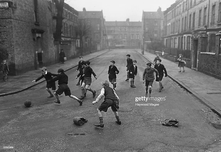 8 апреля 1950: Мальчики играют в футбол на улицах Лондона. (Фото Гейвуда Магии)