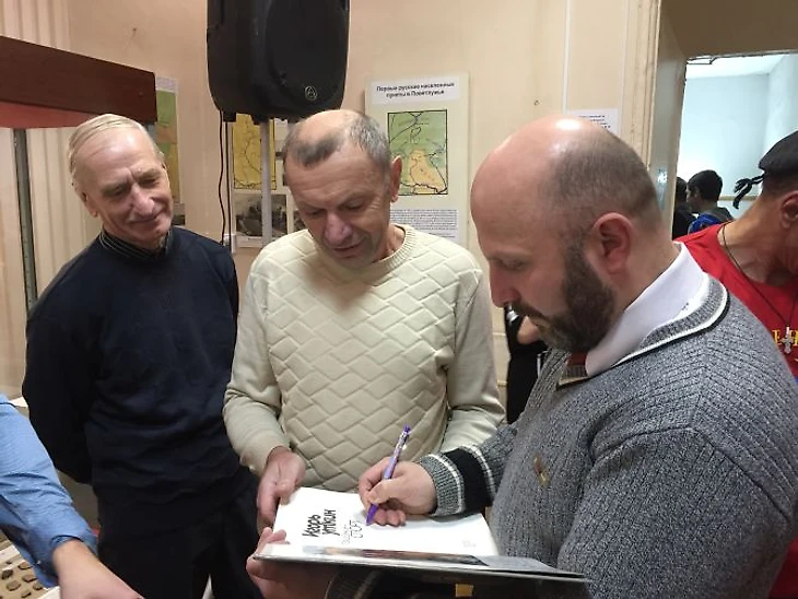 Владимир Песня раздаёт автографы ветеранам ветлужского хоккея и футбола