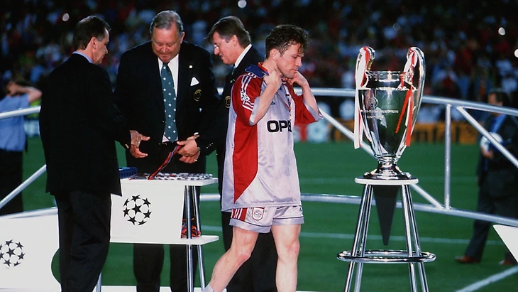 Lothar Matthaus walks past the trophy