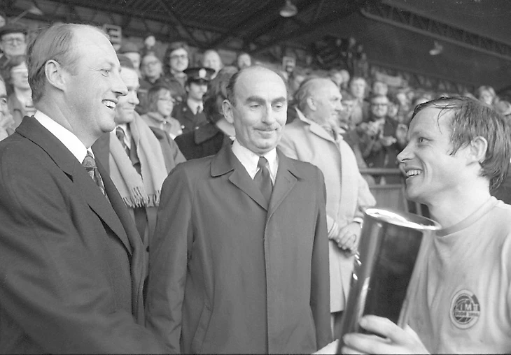 Осло, 1975-1026. Футбол, финал кубка Будё/Глимт – Вард 2-0, стадион «Уллеваал». Капитан Будё/Глимта Харальд Берг получает трофей от наследного принца Харальда. В центре – президент футбола Эйнар Йорум. Фото Арильд Хорднес / NTB / NTB