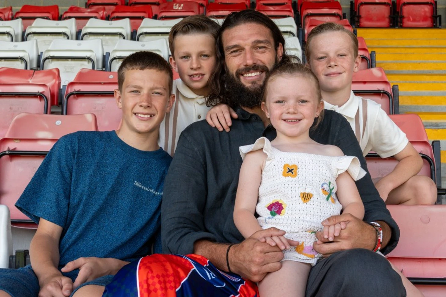 Andy Carroll with his four children in stadium seats.