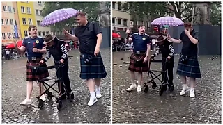 Уважение дня от шотландцев. В дождь сопровождали пожилого человека под своим зонтом